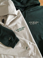 Zwei Hoodies in der Farbe Beige und Forest Green mit jeweils einer Stickerei links auf der Brust und auf dem Ärmel.
