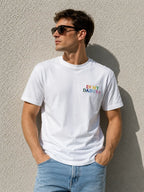 Ein Mann trägt ein weißes personalisiertes T-Shirt, welches bestickt ist. Vorne auf der Brust ist "IN MY DAD ERA" in bunten Farben gestickt. 