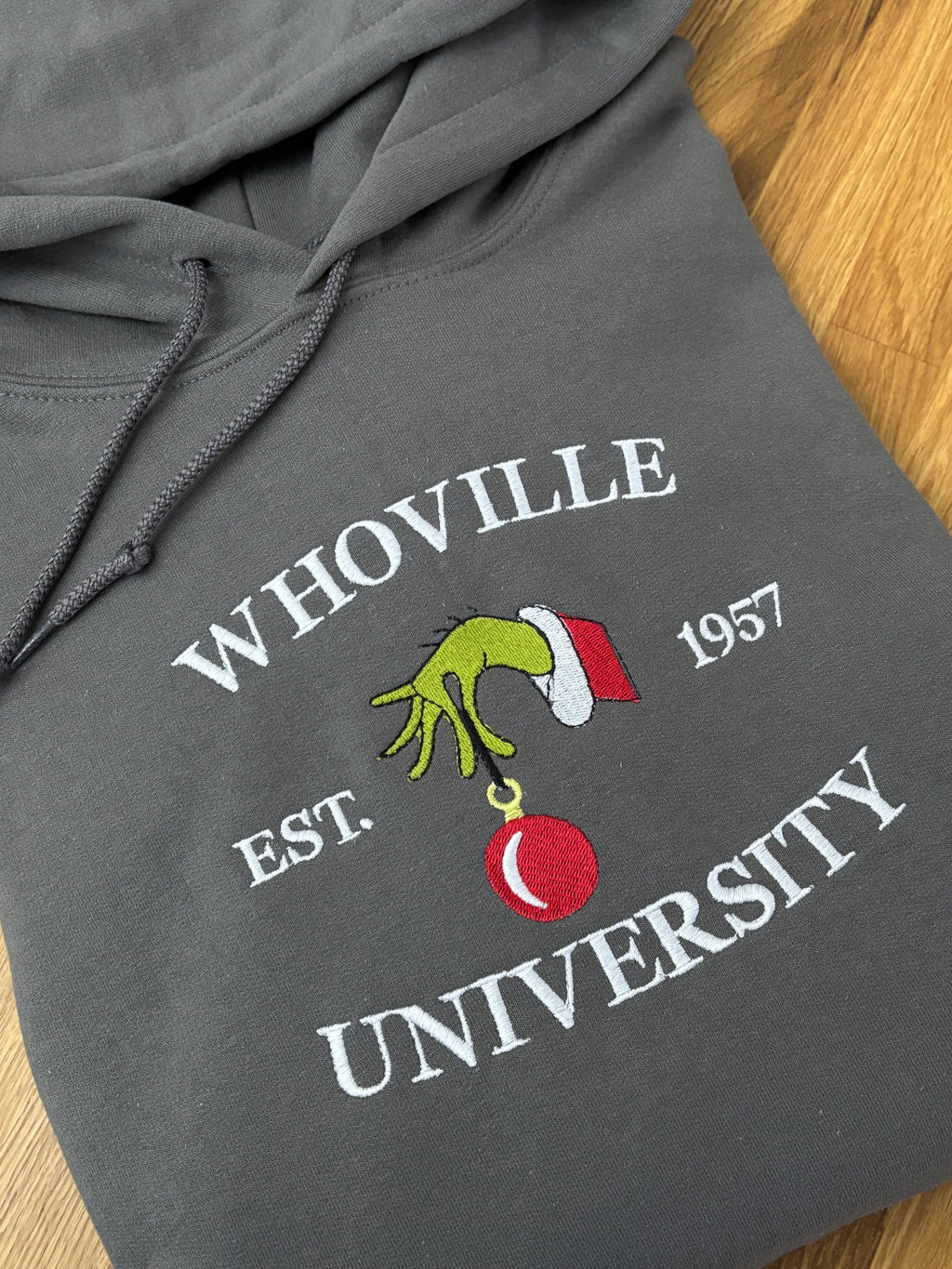 Der Whoville University Grinch Pullover in der Farbe Dunkelgrau. Der Hoodie ist Unisex und von Innen sehr flauschig.
