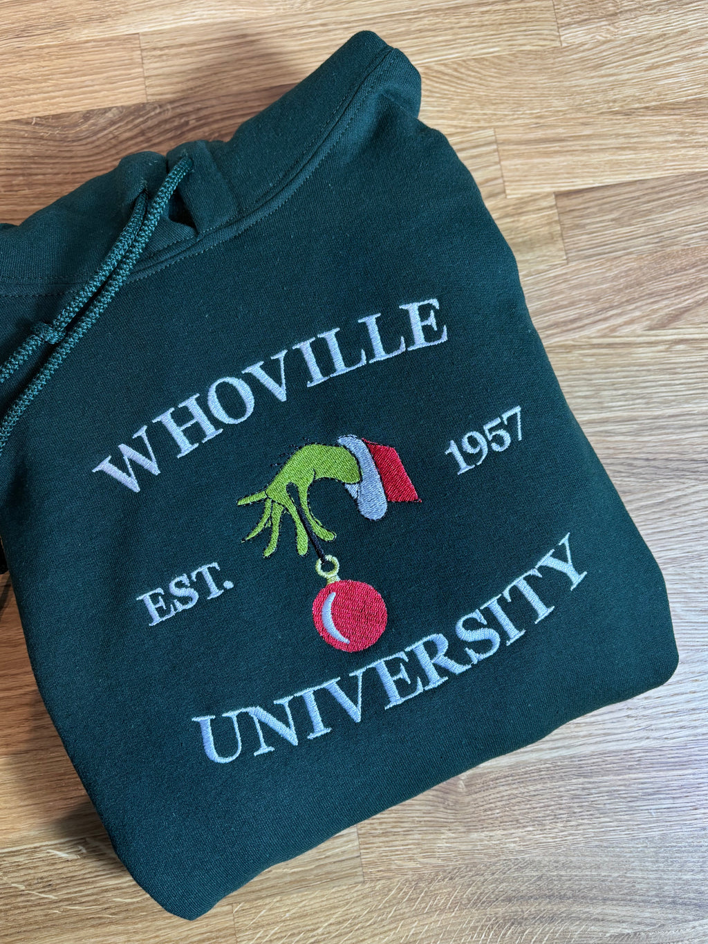Der Whoville University Grinch Pullover in der Farbe Forest Green. Der Hoodie ist Unisex und von Innen sehr flauschig.