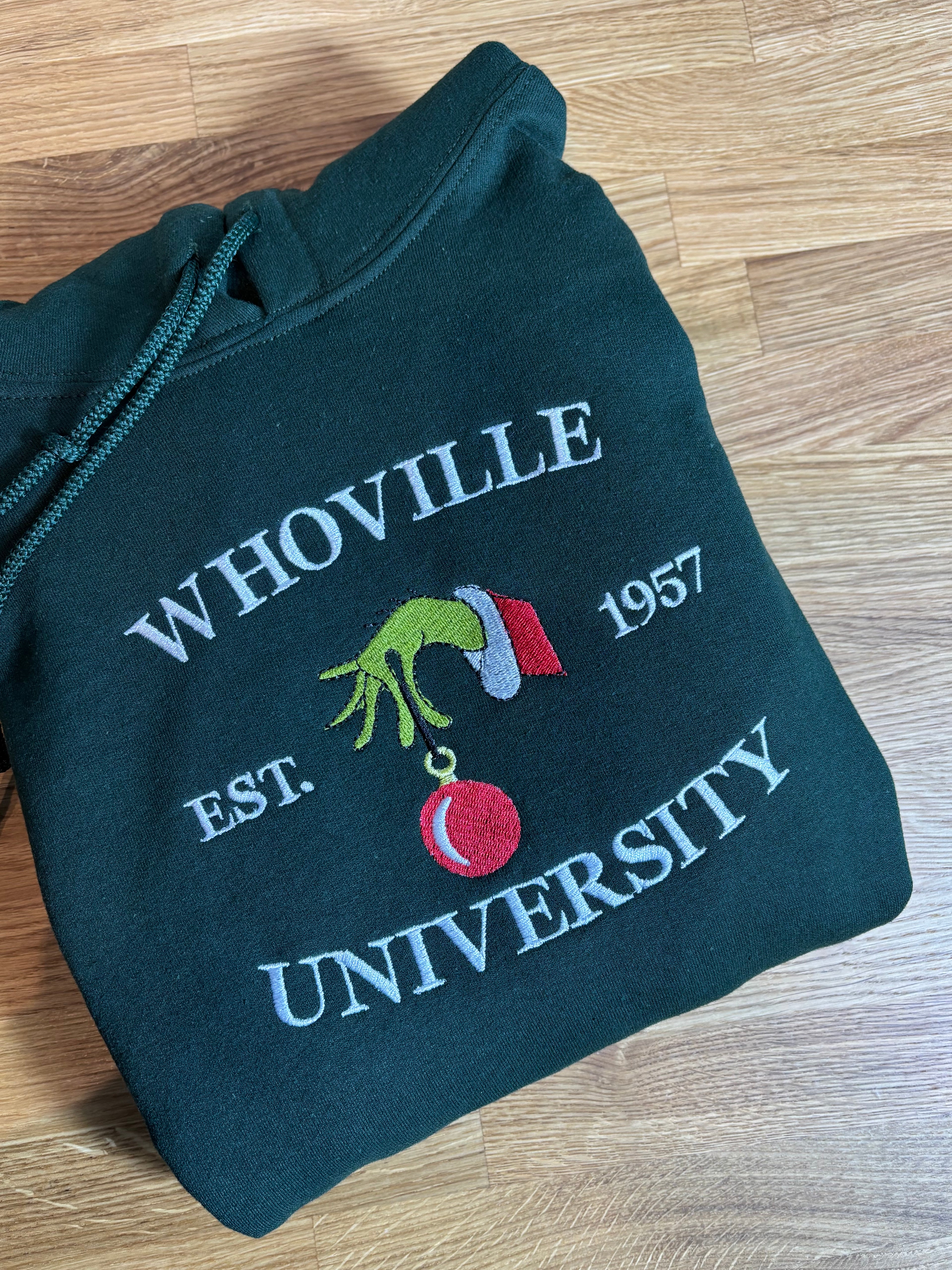 Der Whoville University Grinch Pullover in der Farbe Forest Green. Der Hoodie ist Unisex und von Innen sehr flauschig.
