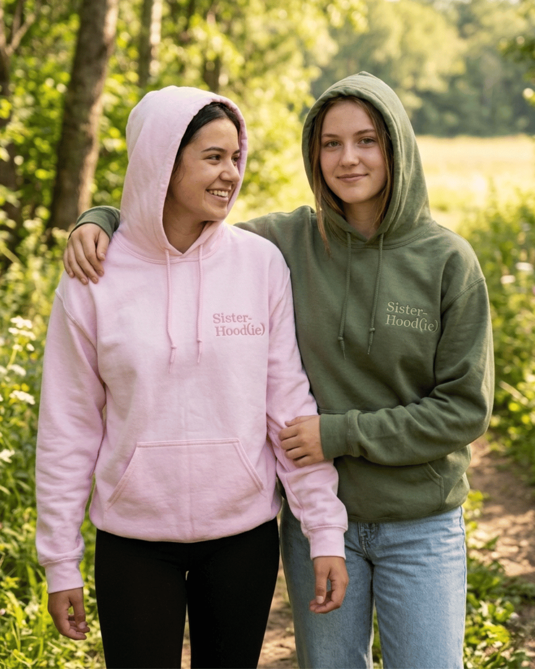 Zwei Schwestern die einen Hoodie tragen, wo auf der Brust "Sister-Hood(ie)" gestickt ist.