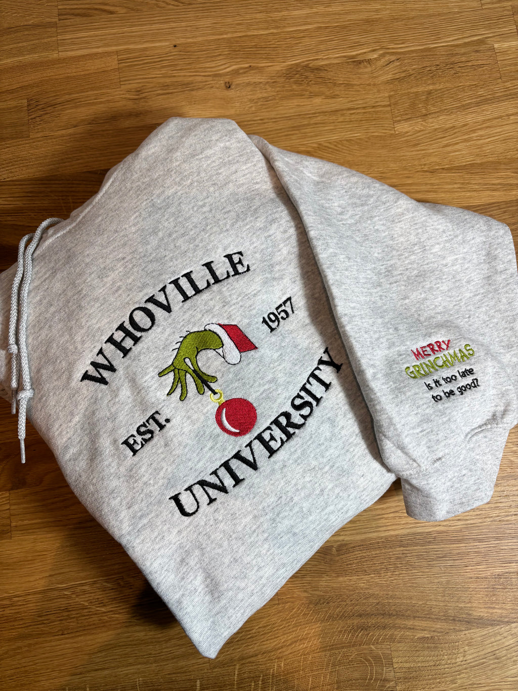 Der Whoville University Grinch Pullover in der Farbe Ash Heather. Der Hoodie ist Unisex und von Innen sehr flauschig. Den Hoodie gibt es als Sweater oder als Pullover mit Kapuze. Auf dem Ärmel ist noch ein Grinch Spruch gestickt: Merry Grinchmas It's too late to be good?