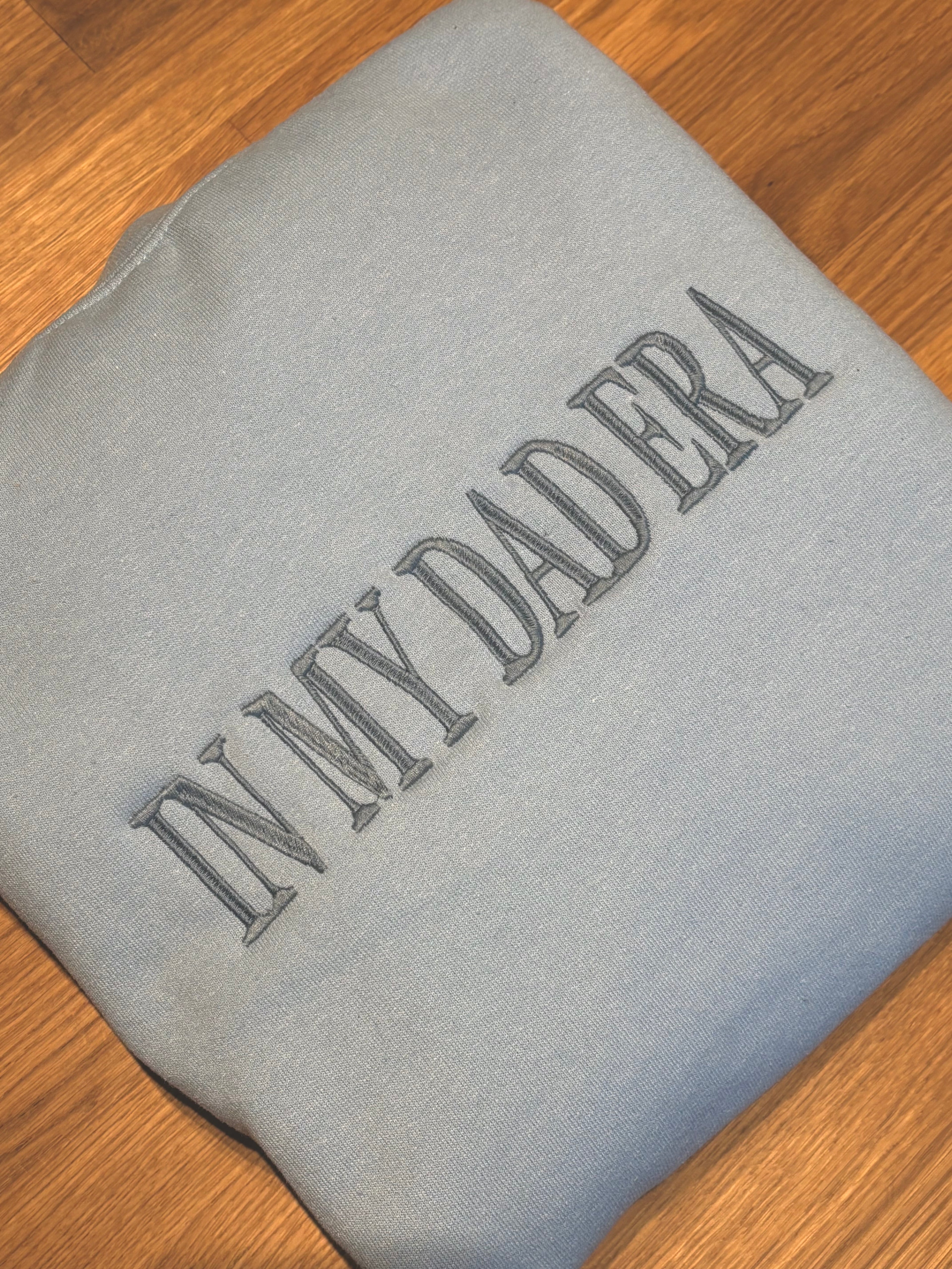 Ein Hoodie in der Farbe Light Blue mit einem bestickten Wunschtext vorne auf der Brust mittig in steel blue "In my dad era".