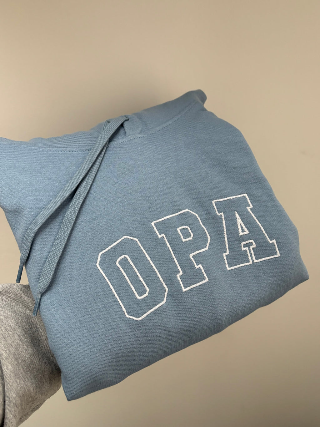 Ein bestickter Pullover in der Farbe Stone Blue OPA in der Garnfarbe weiß.