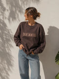 Eine Frau trägt einen personalisierten Sweater mit der Stickerei vorne "IN MY MOM ERA".