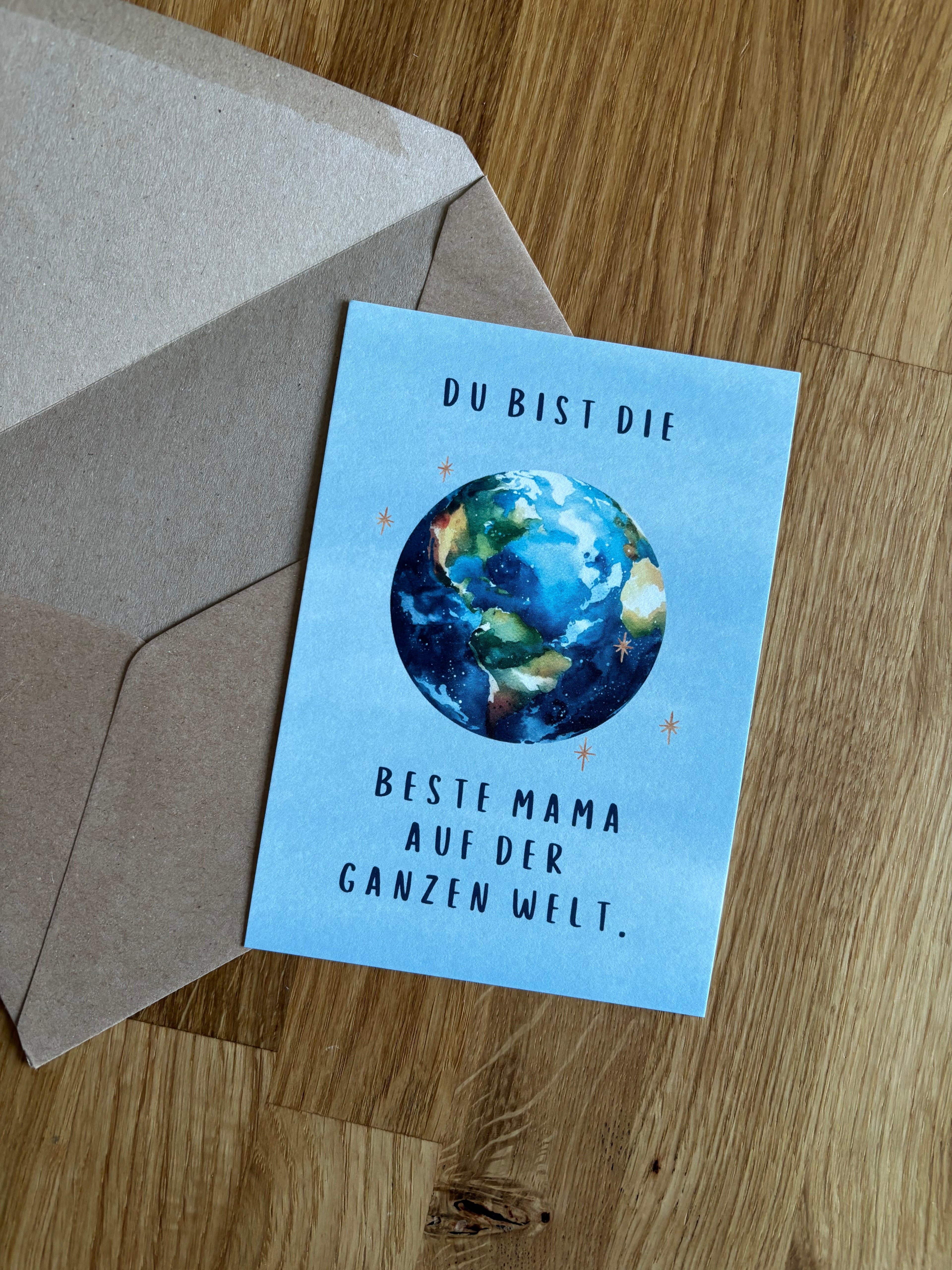 Eine blaue Postkarte "Du bist die beste Mama auf der ganzen Welt" mit einer Weltkugel.