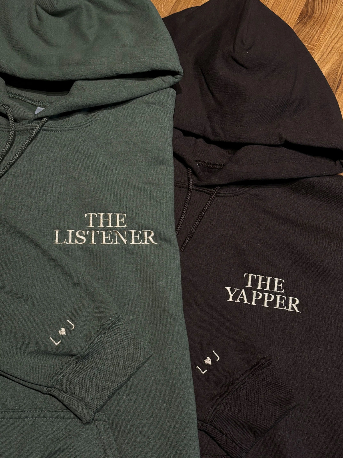 Ein Hoodie in Military Green und in Dark Chocolate sind mit The Yapper und The Listener bestickt. Beide haben zusätzlich eine dezente Stickerei am Ärmel.