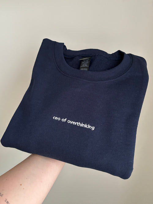 Ein Sweater in der Farbe Navy Blue mit einer Stickerei vorne mittig "ceo of overhinking" in weiß.