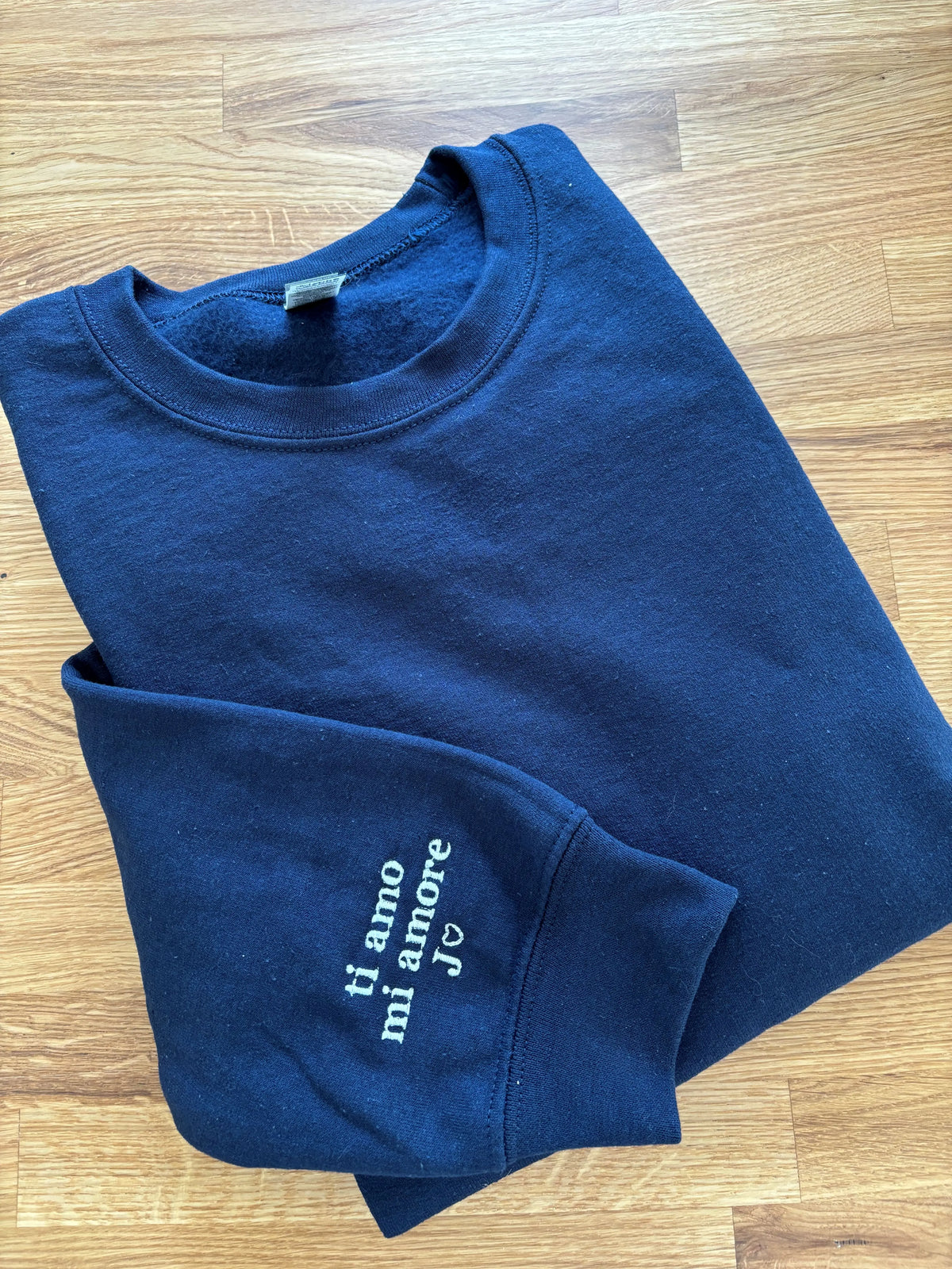 Der Sweater in der Farbe Navy Blue ist mit einer dezenten Stickerei am Ärmel versehen: ti amo mi amore.