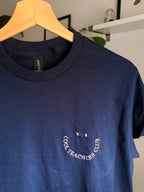 Ein T-Shirt in der Farbe Navy Blue mit einem rosa  Stickerei vorne links auf der Brust „Cool Teachers Club" in Großbuchstaben.