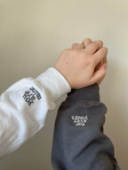 Personalisierte und bestickte Pullover mit einem Ärmelstick. Der Ärmelstick wird jeweils auf einen Ärmel gestickt. Der Kunde kann sich seinen Wunschtext individuell auf den Pullover aufbringen lassen.