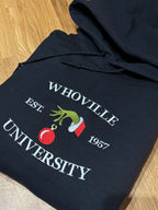Der Whoville University Grinch Pullover in der Farbe Schwarz. Der Hoodie ist Unisex und von Innen sehr flauschig. Den Hoodie gibt es als Sweater oder als Pullover mit Kapuze.