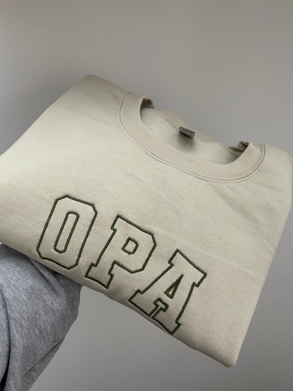 Ein bestickter Sweater in der Farbe Stone Blue OPA in der Garnfarbe green.