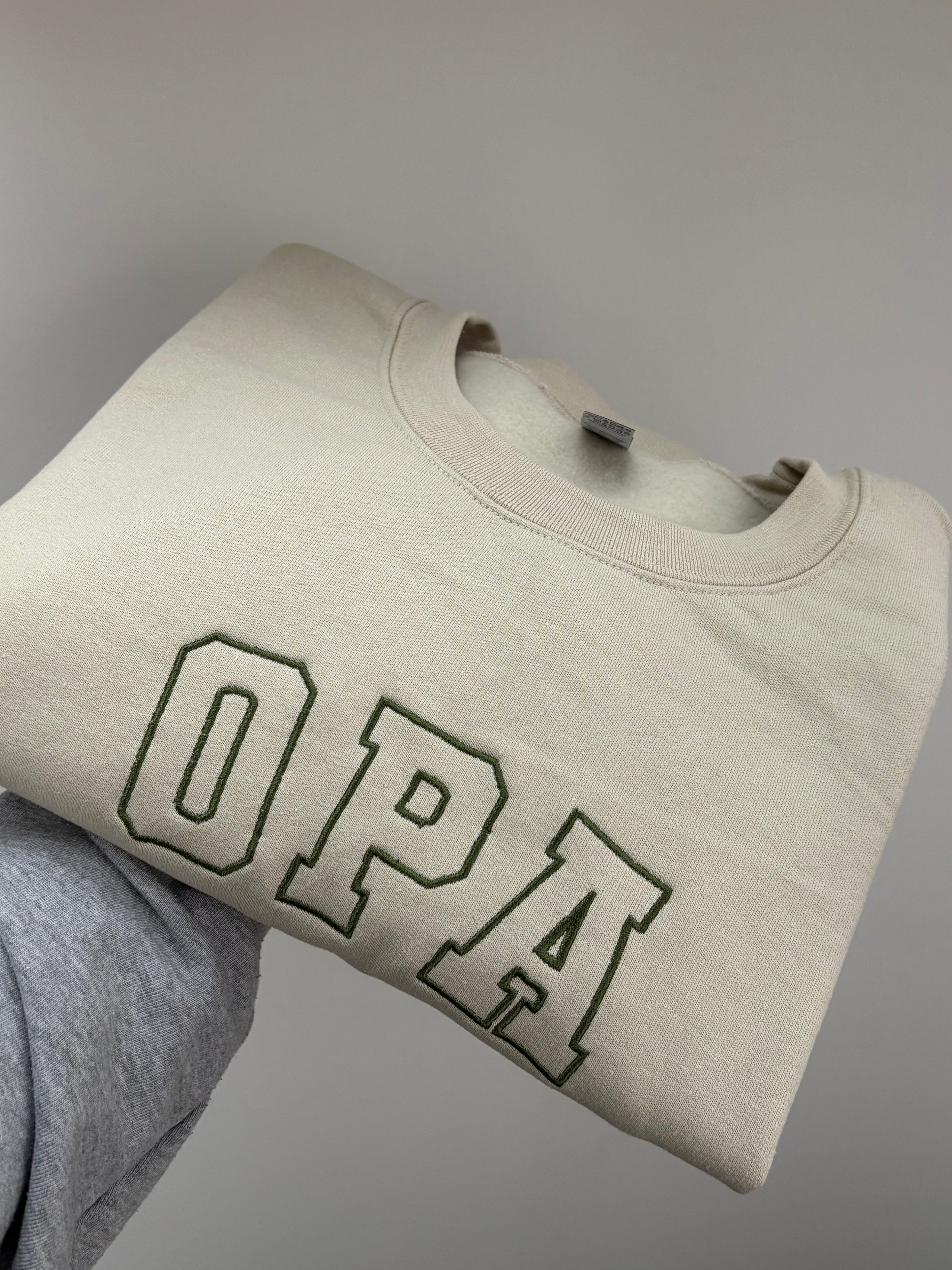 Ein bestickter Sweater in der Farbe Stone Blue OPA in der Garnfarbe green.