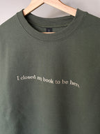 Ein grüner Sweater mit einem beigen Stick I closed my book to be here.