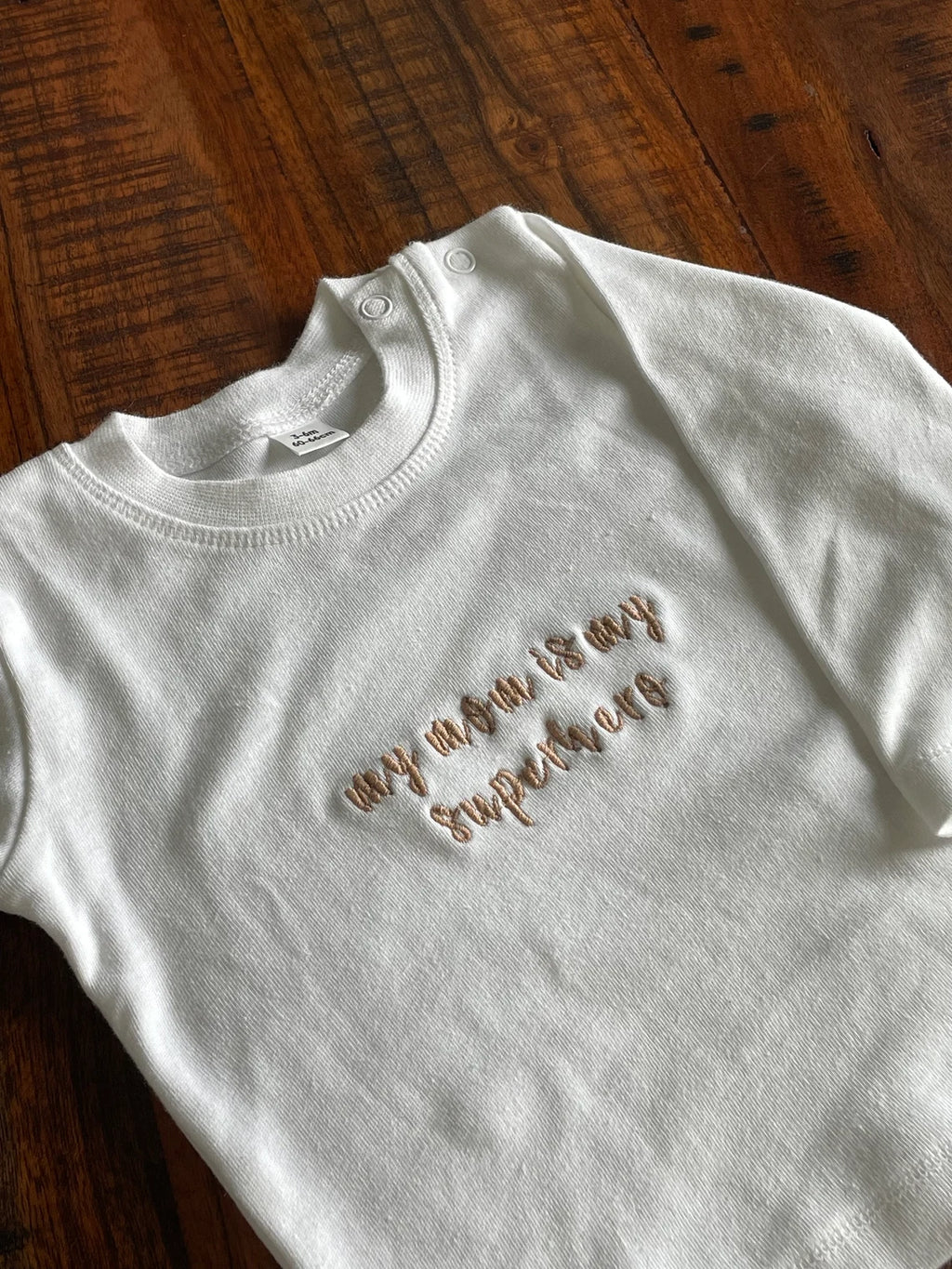 Ein weißes Sweatshirt mit dem Stick "my mom is my superhero".