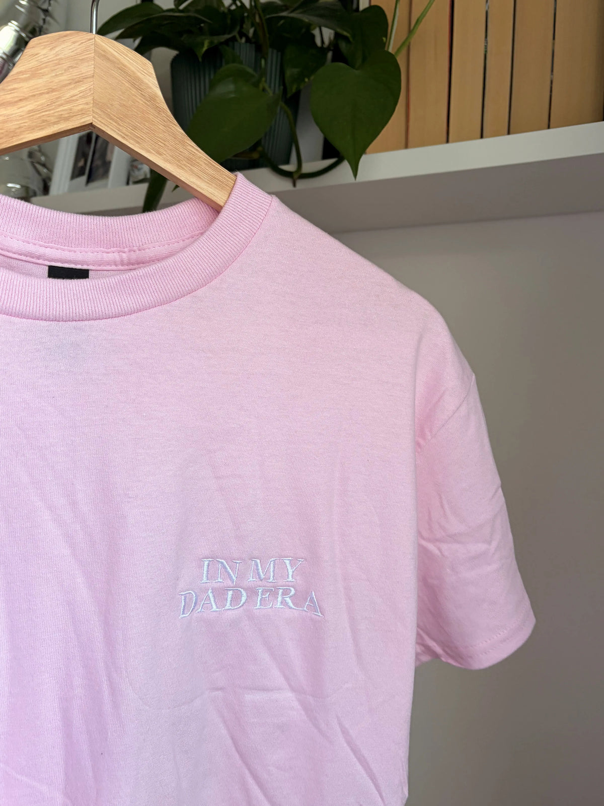 Ein rosa T-Shirt mit einer weißen Stickerei vorne links auf der Brust "In My Dad Era" in Großbuchstaben.