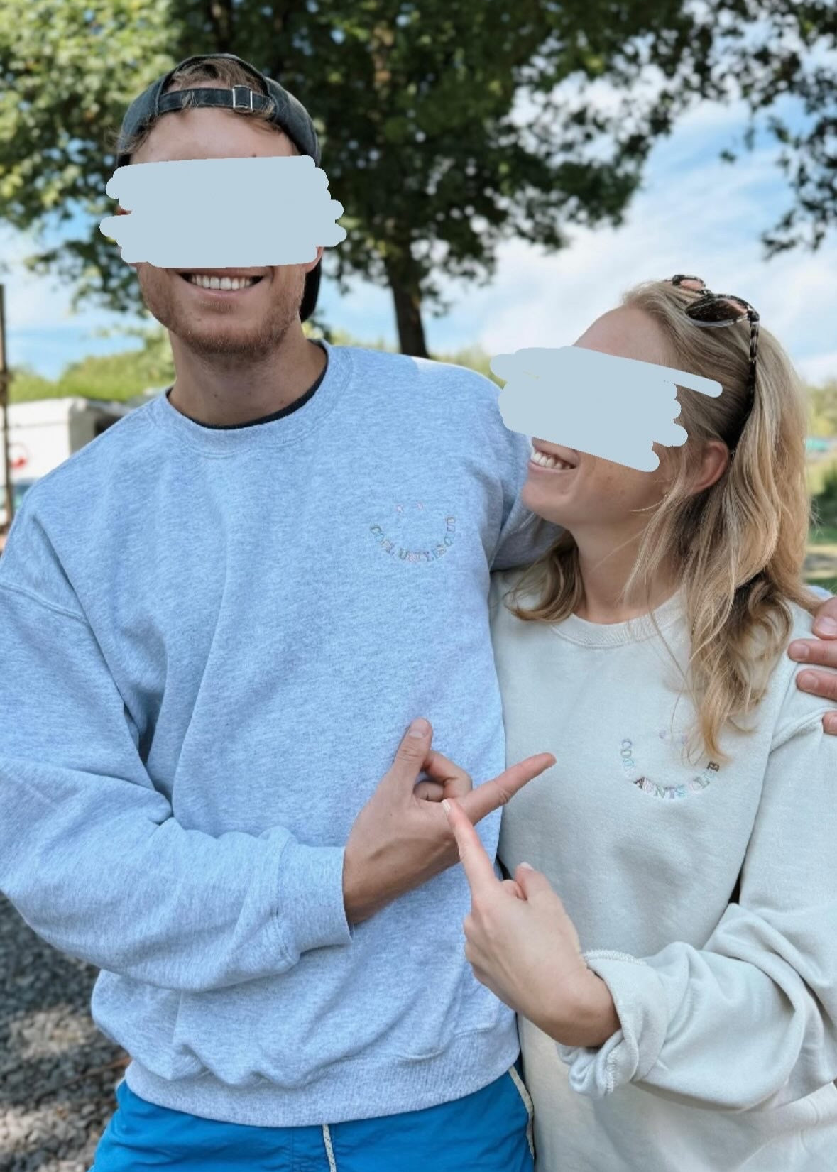 Zwei Geschwister, die jeweils einen Sweater tragen. Links ist ein Mann, der einen hellgrauen Sweater mit dem bunten Stick "Cool Uncles Club" trägt. Rechts trägt die blonde Frau einen beigen Sweater mit einem bunten Stick "Cool Aunts Club".