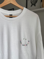 Der Cool Uncles Club Sweater in der Farbe Weis mit buntem Garn bestickt. Der Stick sieht aus wie ein Smiley und ist dezent.