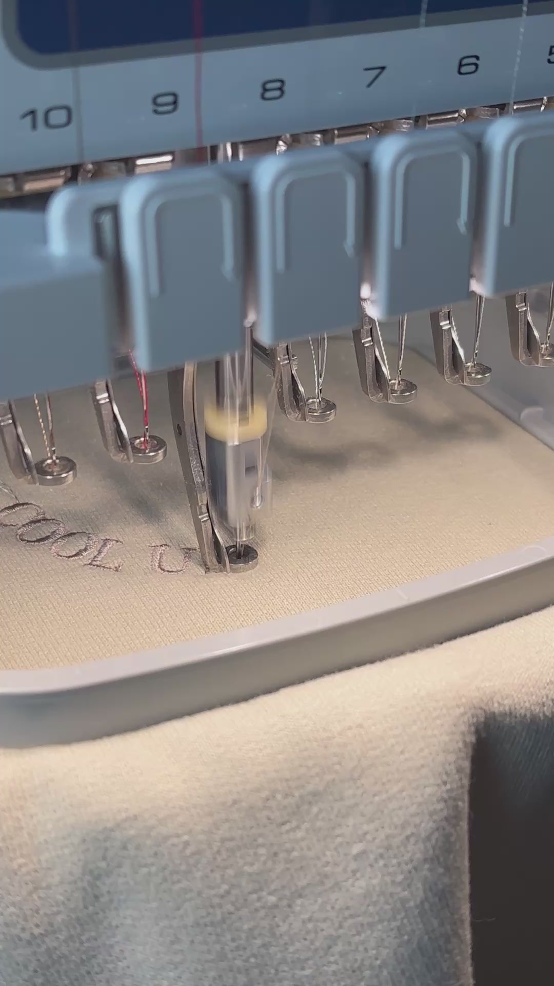 Ein beiger Sweater mit einer beigen Stickerei Cool Uncles Club in Form eines Smileys.