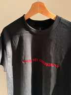Ein schwarzes T-Shirt mit einer roten Stickerei vorne mittig auf der Brust "I LOVE MY GIRLFRIEND".