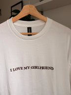 Ein weißes T-Shirt mit einer dunkelbraunen Stickerei vorne mittig auf der Brust "I LOVE MY GIRLFRIEND".