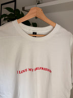 Ein weißes T-Shirt mit einer roten Stickerei vorne mittig auf der Brust "I LOVE MY GIRLFRIEND".